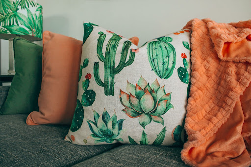 A colorful throw pillow with a cactus motif. 