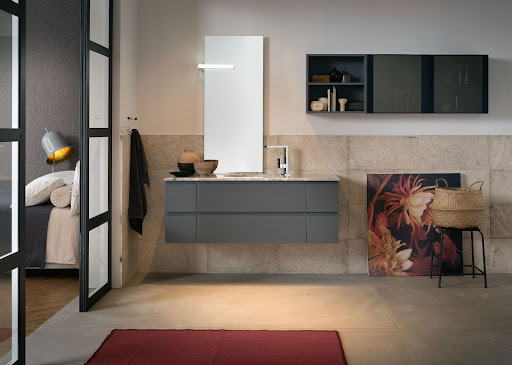 A bathroom design with a red rug and accent mirror that maximizes space.