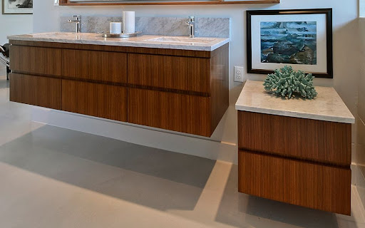 A floating bathroom vanity and counter with picture frame and houseplant accessories.
